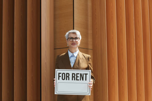 istock Real estate agent with placard outdoors 1251286095