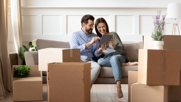 istock Excited young couple having fun with tablet on moving day 1251286941