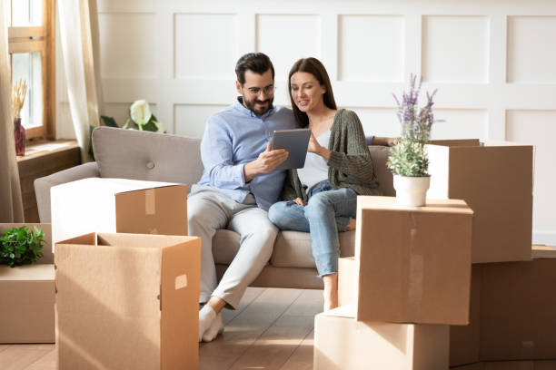 istock Smiling woman and man using tablet, choosing moving service 1251286946