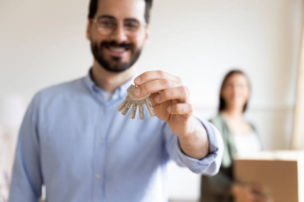 istock Close up smiling husband showing keys, celebrating moving day 1251286954