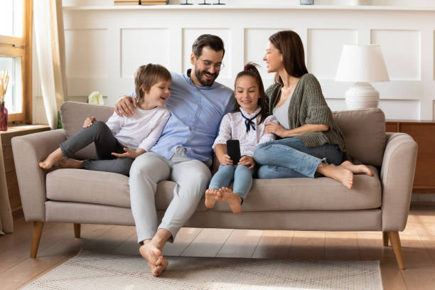 istock Happy parents with son and daughter relaxing on couch 1251287035
