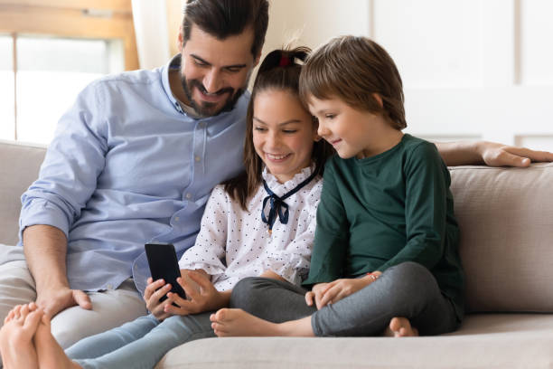 istock Loving father with children having fun with smartphone 1251287065