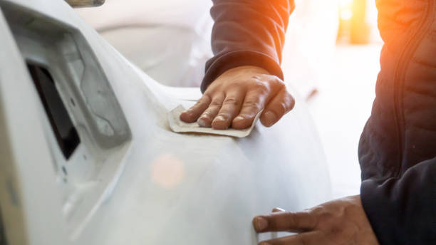 Auto mechanic working on car paint sanding in mechanics garage. workshop repair service. authentic close-up shot. Auto mechanic working on car paint sanding in mechanics garage. workshop repair service. authentic close-up shot car bodywork stock pictures, royalty-free photos & images