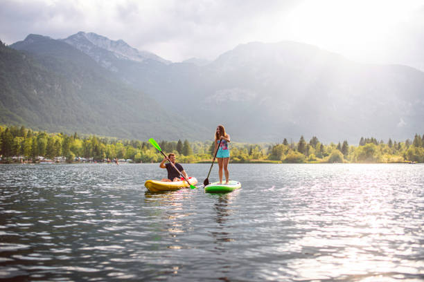 パドルボーダーとフラットウォーターカヤッカーはボーヒニ湖を探索 - julian alps lake bohinj lake bohinj ストックフォトと画像