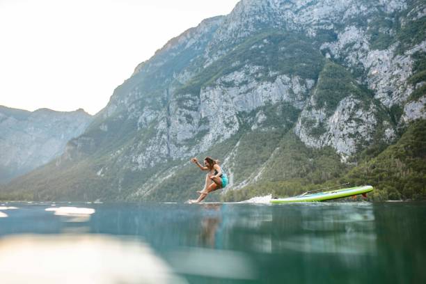 istock Laughing Woman Jumping from Paddleboard into Lake Bohinj 1251297029