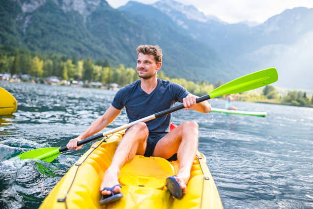 relaxed male in early 30s kayaking in lake bohinj - sport exercising men julian alps imagens e fotografias de stock