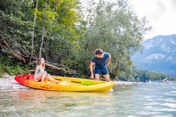 istock Mid Adult Couple Pulling Kayak into Lake for Weekend Paddle 1251297080
