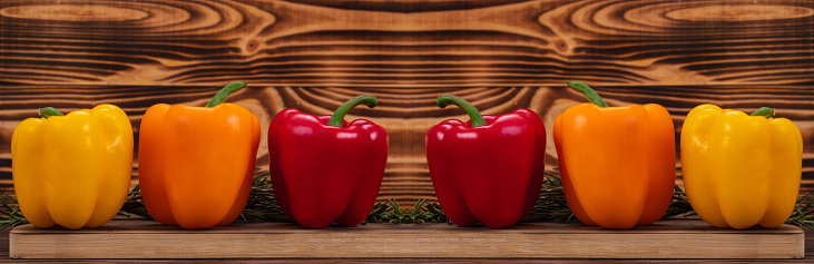 Fresh vegetables, bell peppers of different colors with rosemary on cutting wooden boards. Duplicate image on the middle with copy space