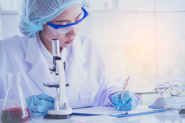 女性科学者は顕微鏡を見て、科学試験管は実験室の実験バイオテクノロジーで科学的サンプルを分析し、ウイルスに対するワクチンを栽培します。化学科学研究室のコンセプト - medical laboratory ストックフォトと画像