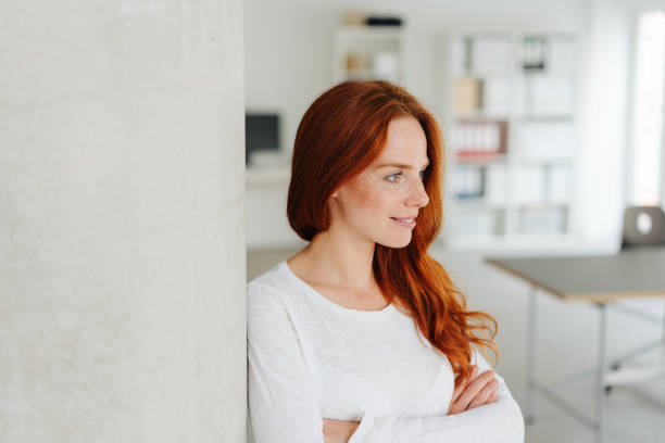 istock Thoughtful young businesswoman with folded arms 1251303964