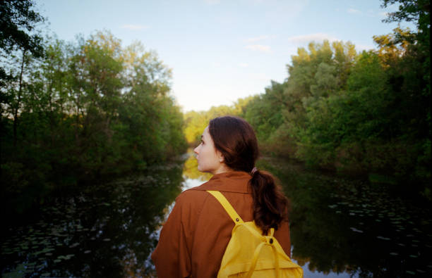 istock Woman standing on bridge and looking at river 1251304669