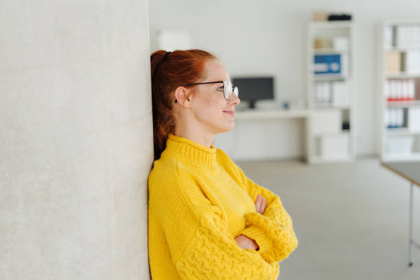istock Nostalgic young woman daydreaming at the office 1251304864