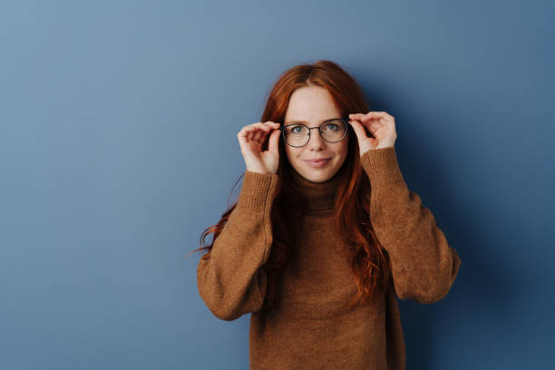 istock Pretty woman with hands raised to her glasses 1251305794