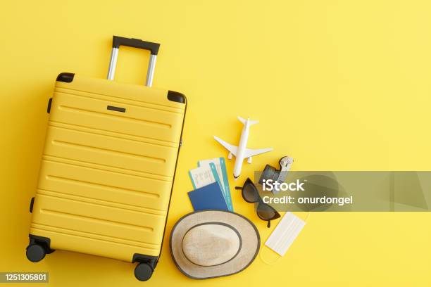 Medizinische Maske Koffer Mit Sonnenhut Kamera Reisepass Flugzeugticket Sonnenbrille Und Flugzeug Auf Gelbem Hintergrund Stockfoto und mehr Bilder von Reise