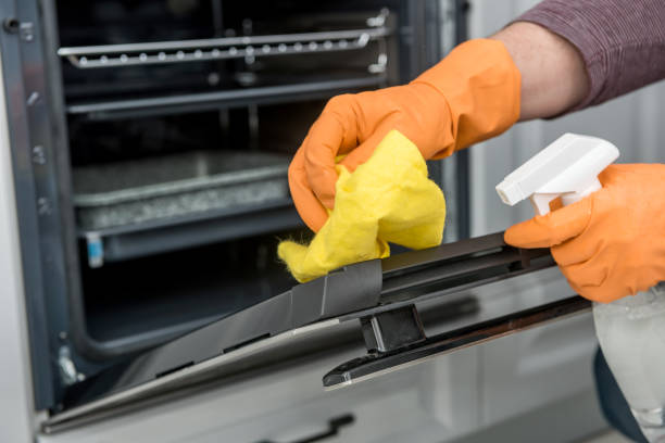 Man's hand in gloves cleaning the kitchen oven Man's hand in gloves cleaning the kitchen oven. housework cleaning stove domestic kitchen human hand stock pictures, royalty-free photos & images