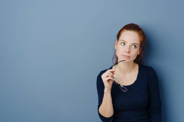 istock Thoughtful young redhead woman with glasses 1251307858