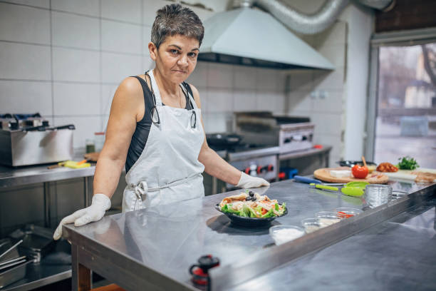 istock Senior woman serve food on a plate 1251308452
