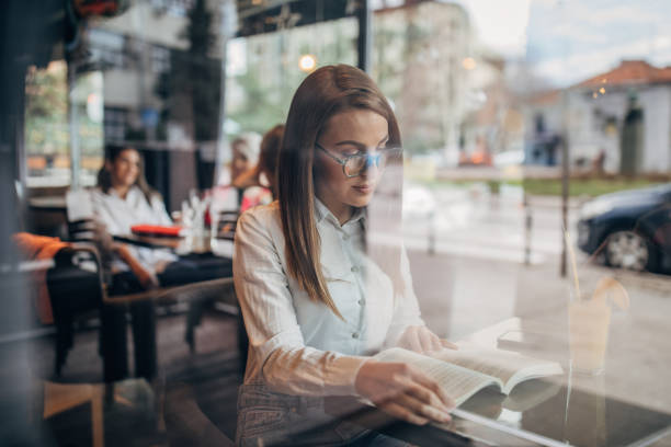 istock Lady sitting in cafe and reading a book 1251308529