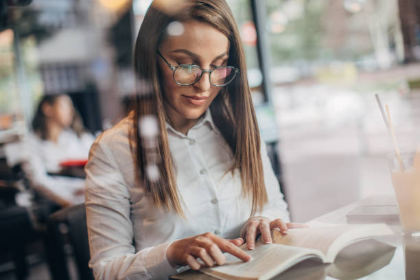 istock Lady sitting in cafe and reading a book 1251308545