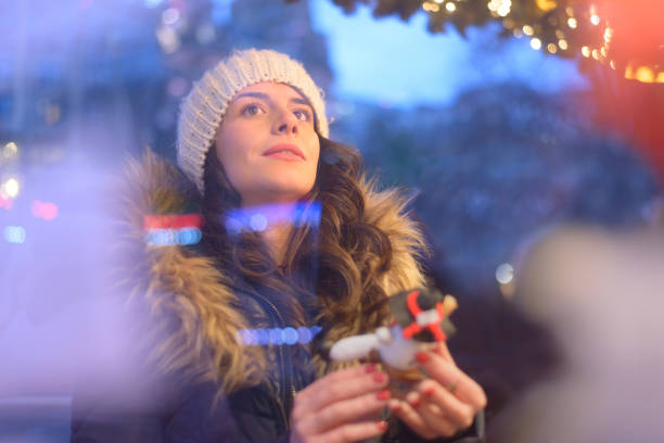 Generation Z young woman shopping for crafts at the winter Christmas market. Shot in Edinburgh, Scotland.