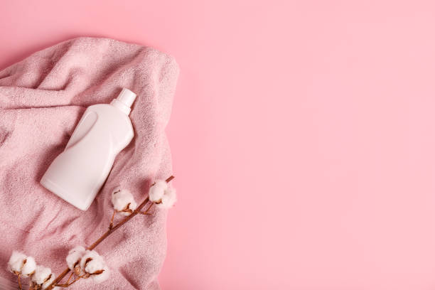 istock Brown bath towel, cotton branch and detergent on pink background 1251308874