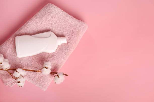 istock Bath towel, cotton branch and detergent on pink background 1251308888