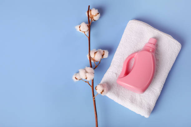 istock White bath towel, detergent and cotton branch on blue background 1251309000