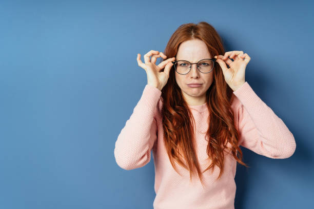 istock Grumpy young woman adjusting her glasses 1251309023