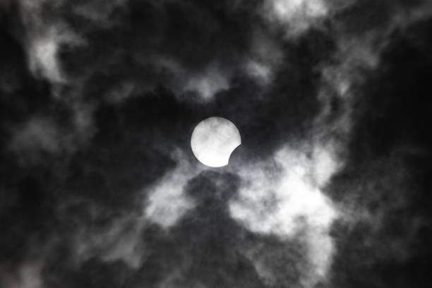 istock Partial solar eclipse close-up on a background of gloomy clouds 1251309279