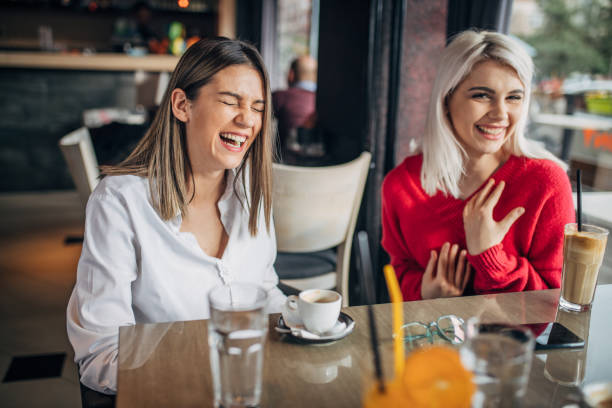 istock Two young women sitting indoors in cafe 1251309490