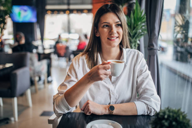istock Young woman enjoying in coffee alone in cafe 1251310621