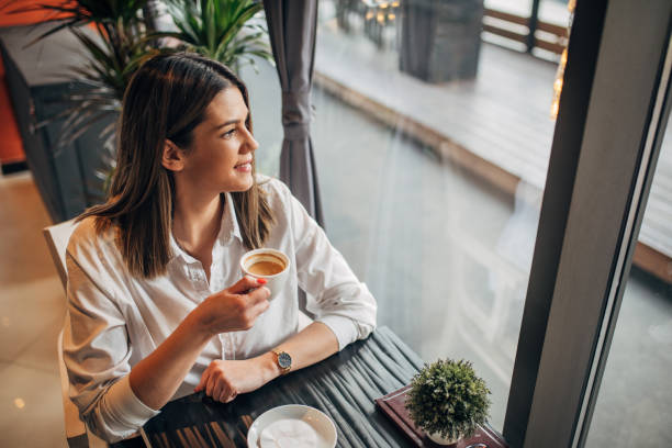istock Young woman sitting alone in cafe 1251310712