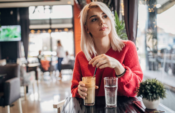 istock Young woman sitting in cafe alone 1251310863