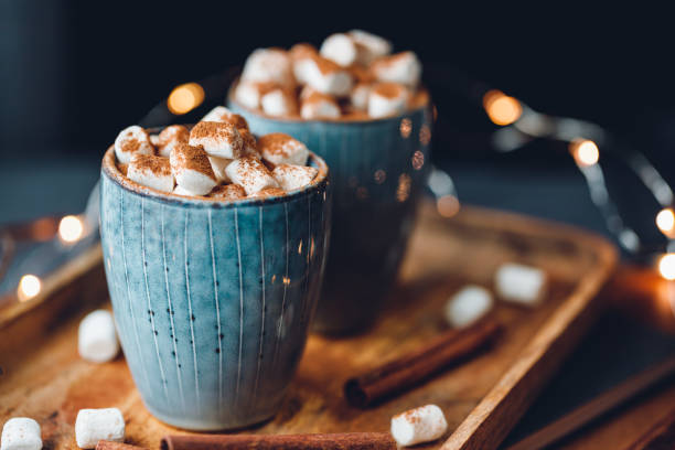 istock Hot chocolate with marshmallow and cinnamon in blue ceramic cups on a table. The concept of cosy holidays and New Year. 1251312721
