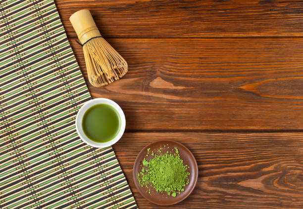 istock Green matcha tea in a cup with powdered tea and tea whisk 1251313536