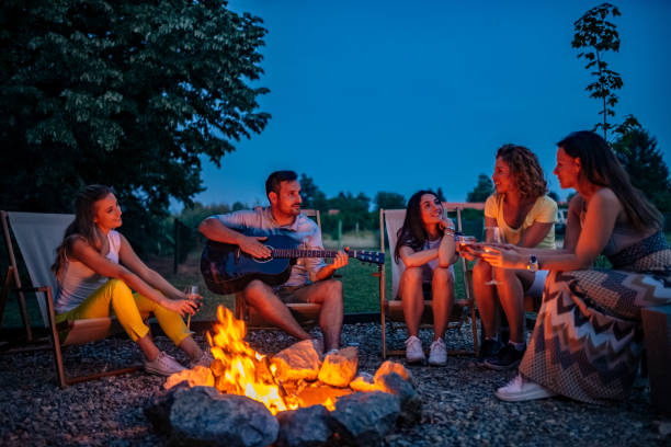 istock Friends enjoying music while sitting around bonfire at night. 1251314062