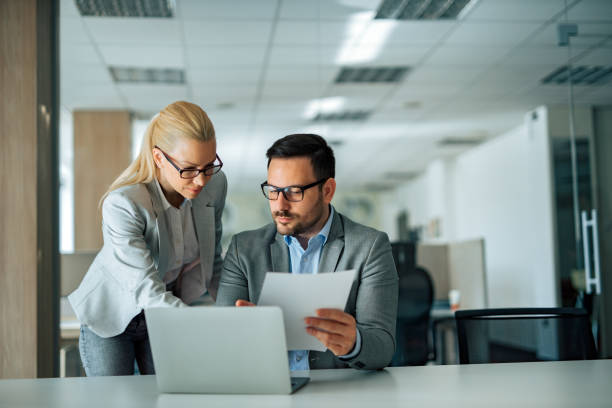 istock Manager discussing work with employee in the office, portrait, front view. 1251314147