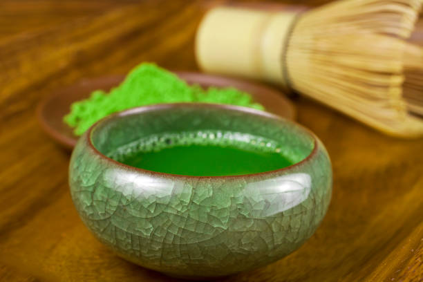 istock Green matcha tea in a cup with powdered tea and tea whisk. 1251315305