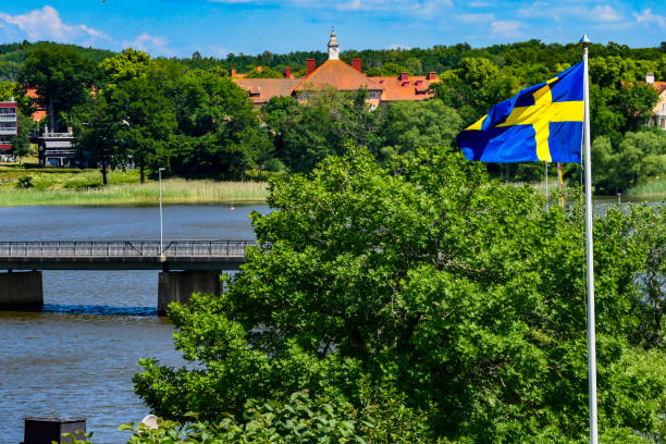 Strangnas, Sweden Strangnas, Sweden June 20, 2020 A Swedish flag flies over the town and a bridge over Lake Malaren. lake malaren photos stock pictures, royalty-free photos & images