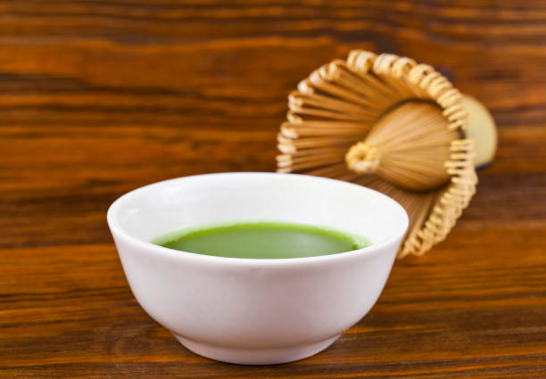istock Green matcha tea in a cup with tea whisk. 1251315993