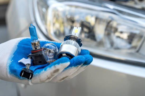 istock Mechanic changing new halogen bulb in car headlight 1251317470