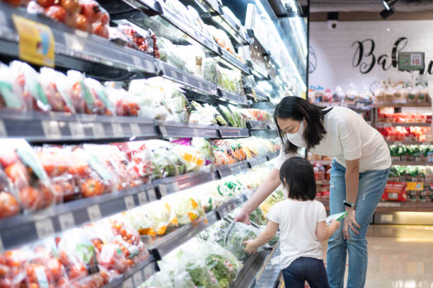 young asian woman and 2 year old kid with face mask in supermarket. - asian ethnicity shopping mall supermarket store imagens e fotografias de stock