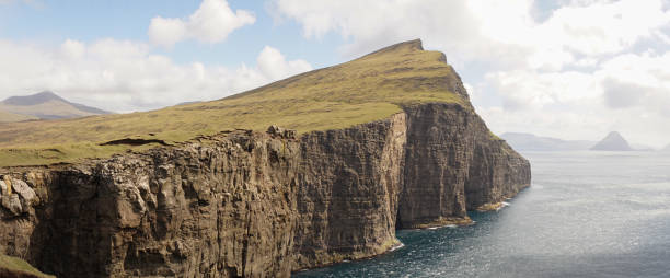Trælanípa Slave Cliff and Leitisvatn Lake mountain landscapes in the Faroe Islands of Denmark. Trælanípa Slave Cliff and Leitisvatn Lake mountain landscapes in the Faroe Islands of Denmark. vágar photos stock pictures, royalty-free photos & images