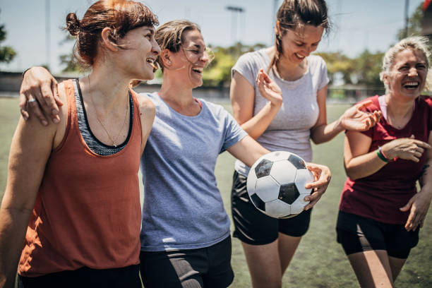 Female soccer players enjoying time together on soccer field Group of women, female soccer players, enjoying time together outdoors on soccer field. football player girlfriend stock pictures, royalty-free photos & images