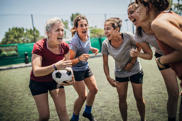Women enjoying time together outdoors on soccer field Group of women, female soccer players, enjoying time together outdoors on soccer field. football player girlfriend stock pictures, royalty-free photos & images