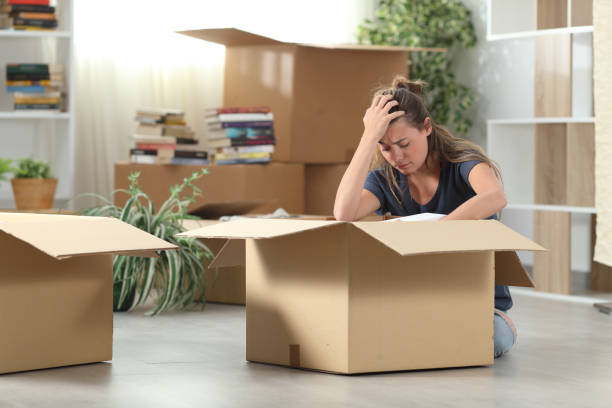 istock Sad evicted woman moving out packing boxes at home 1251321549