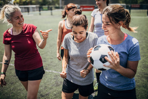 Women enjoying time together outdoors on soccer field Group of women, female soccer players, enjoying time together outdoors on soccer field. football player girlfriend stock pictures, royalty-free photos & images