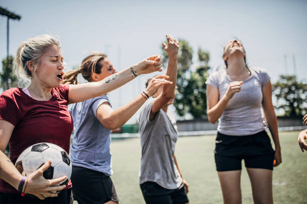 Women enjoying time together on soccer field Group of women, female soccer players, enjoying time together outdoors on soccer field. football player girlfriend stock pictures, royalty-free photos & images