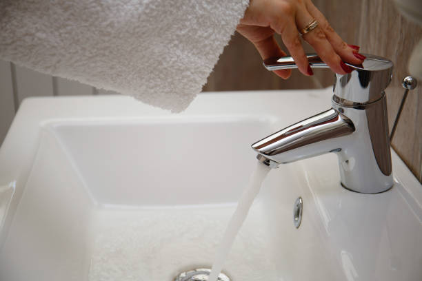 istock Woman's hand opens the faucet in the bathroom 1251323068