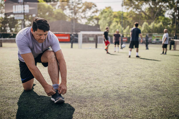 istock Men tying shoelace on soccer field 1251323240